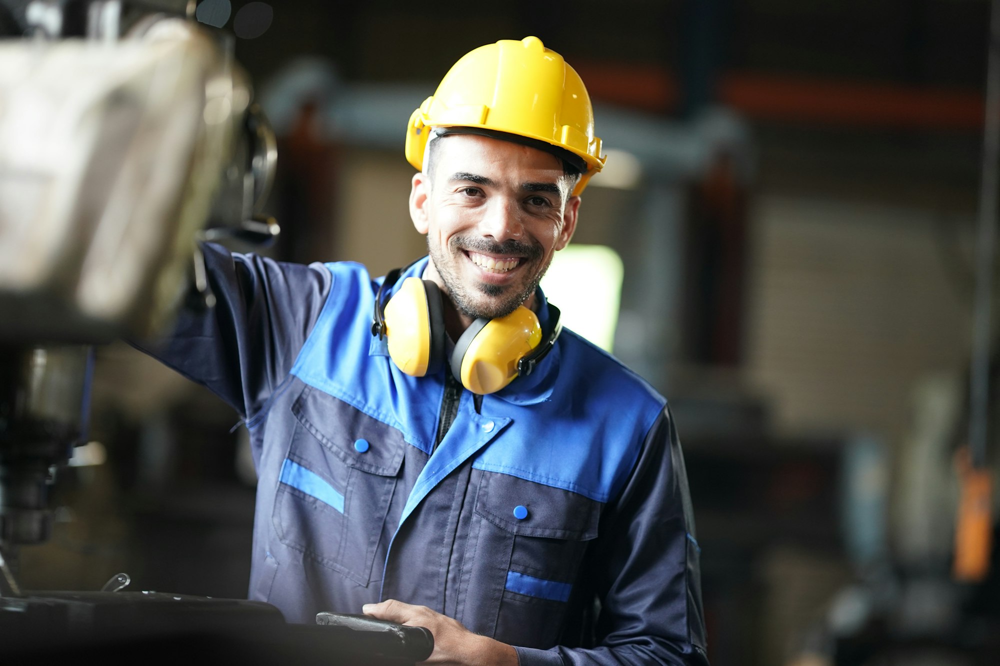 Worker at machine in factory, Metal industry worker at factory.